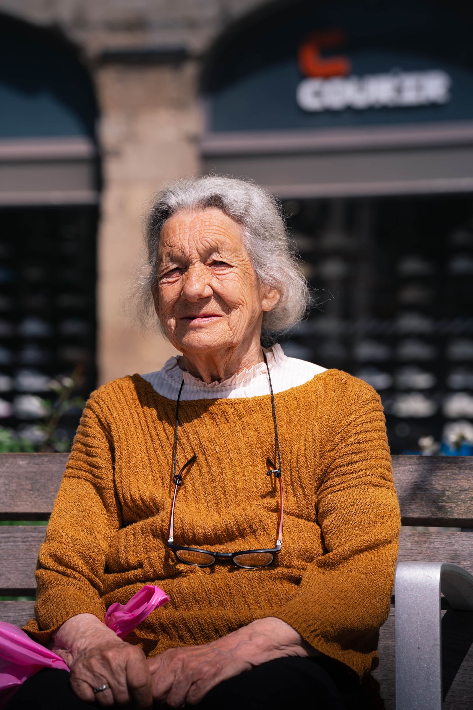 Two retirees laughing together on a bench outdoors