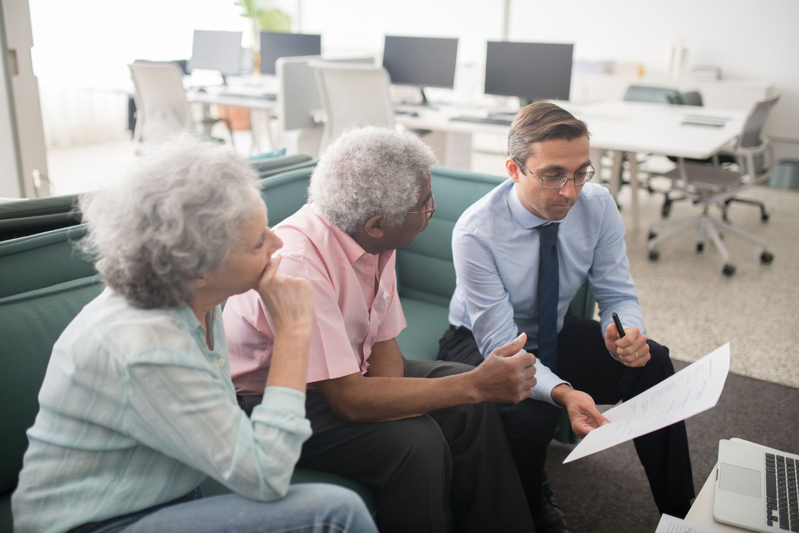 Licensed advisor going through plan paperwork with clients at a table
